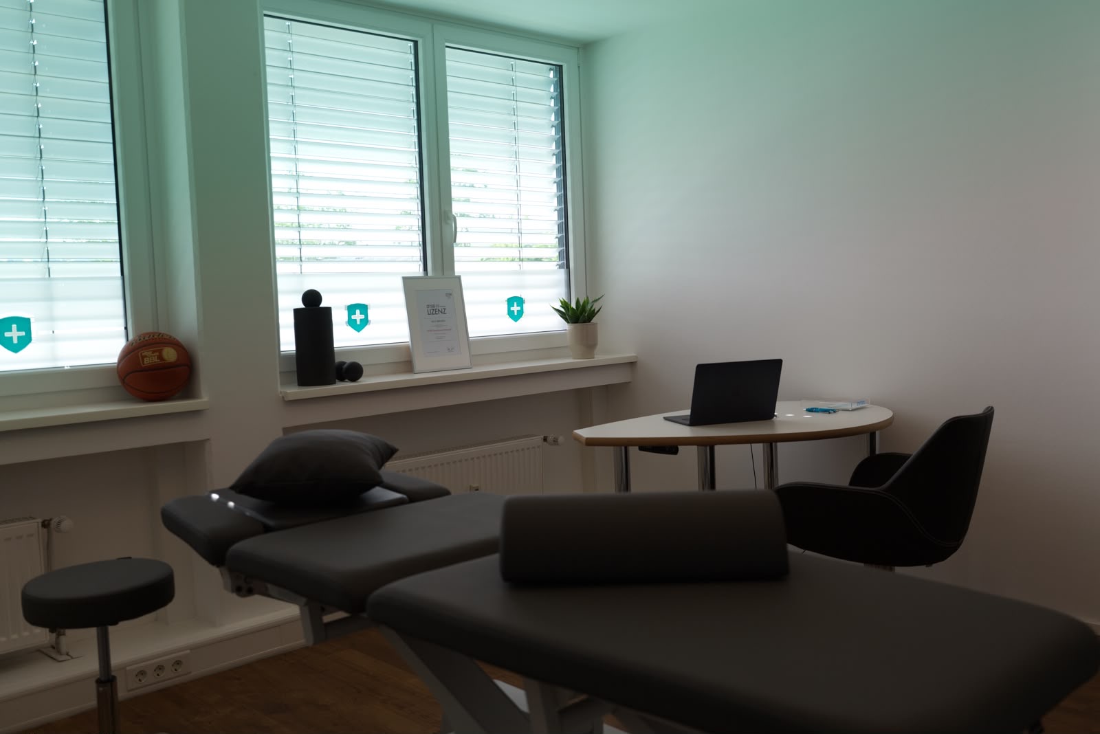 Heller, ruhiger Behandlungsraum mit Behandlungsliege und Tageslicht
